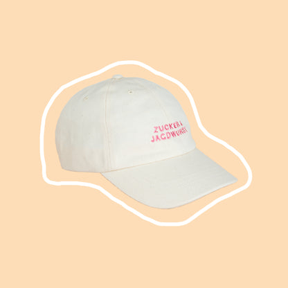 Seitliche Ansicht einer weißen Kappe mit pinker Stickerei ‚Zucker & Jagdwurst‘
